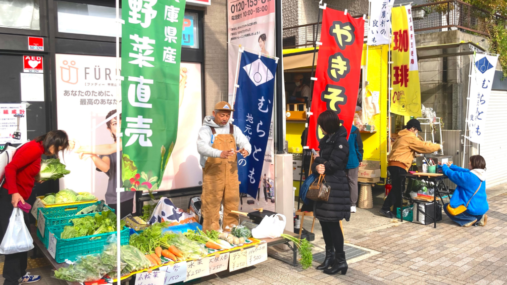 地域の生産者や事業者と都市の人々をつなぐむらともSTATIONの出店風景。神戸市東灘区、女性専用フィットネスジム、ファディー甲南山手駅前店で開催の様子。三田市農家の清水さんと、村のキッチンカー「わをん」が出店しています。
